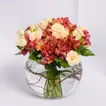 تنسيق أنيق للزهور الخوخية والألستروميريا في وعاء زجاجي