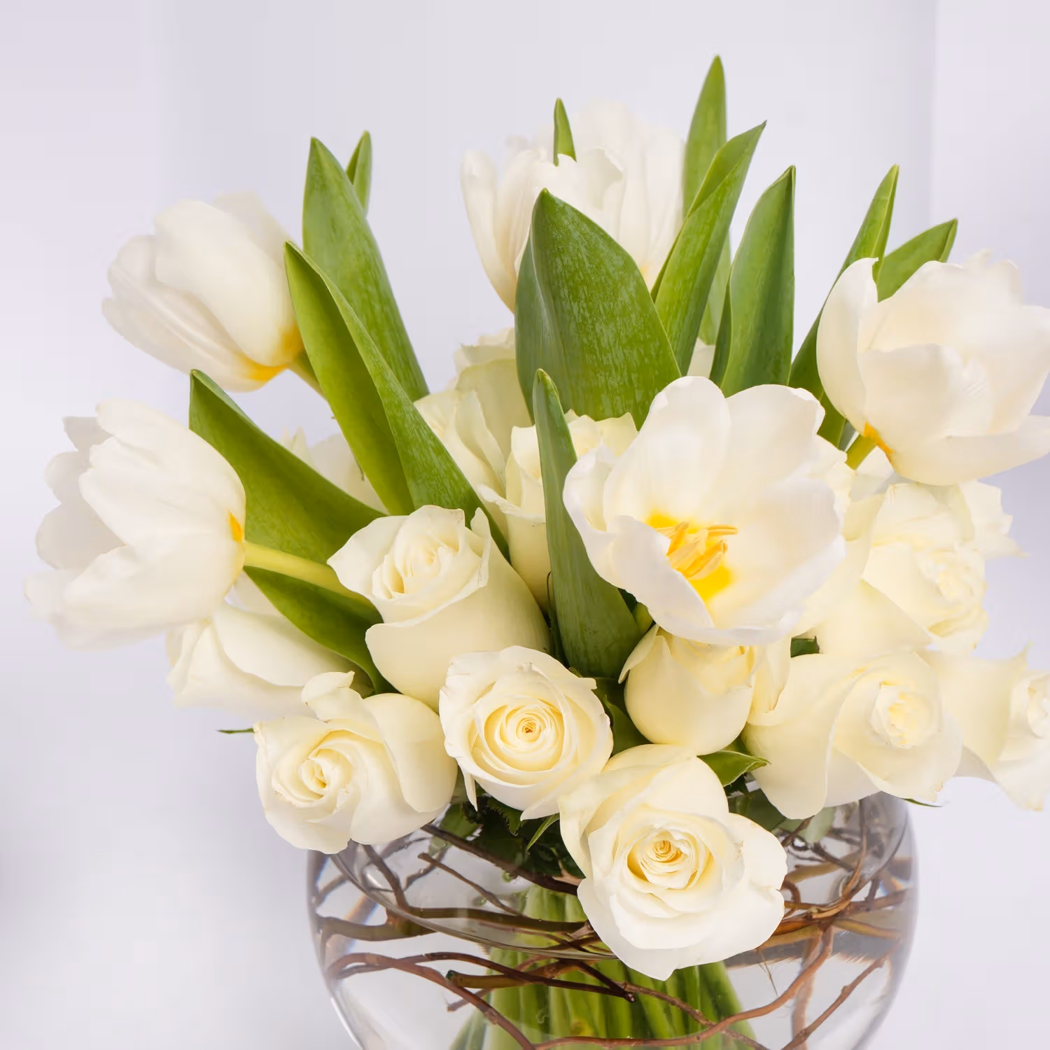 Elegant White Roses and Tulips in a Decorative Glass Vase