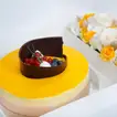 Exquisite Tropical Mango Tango Cake with Elegant Floral Arrangement