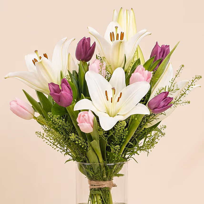 Medley Of Lilies And Tulips In Glass Vase