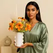 ترتيب أنيق لزهور التوليب البرتقالية في مزهرية بيضاء مصممة