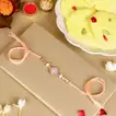 Elegant Rosy American Diamond Rakhi with 1 Kg Ras Malai Delight and Complimentary Roli Chawal