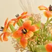 ترتيب أنيق لزهور التوليب البرتقالية في مزهرية بيضاء مصممة