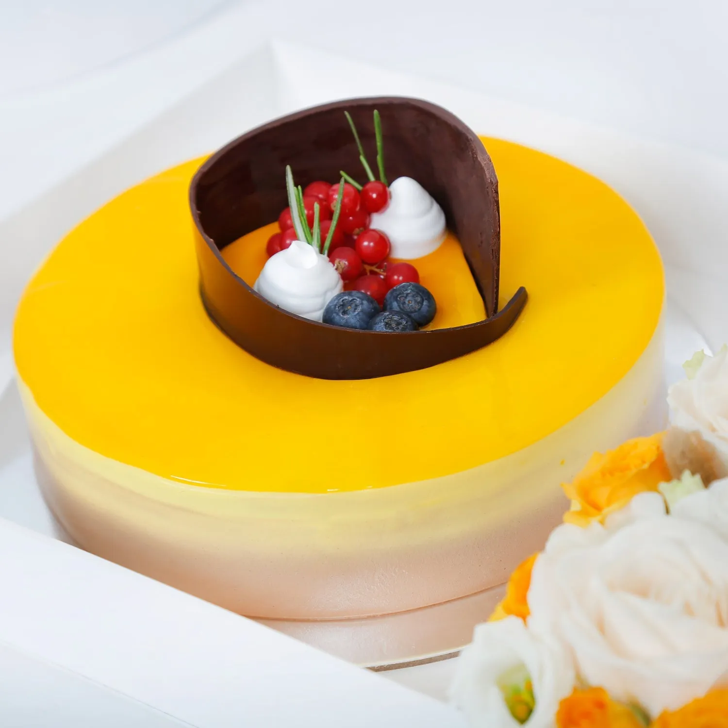 Exquisite Tropical Mango Tango Cake with Elegant Floral Arrangement