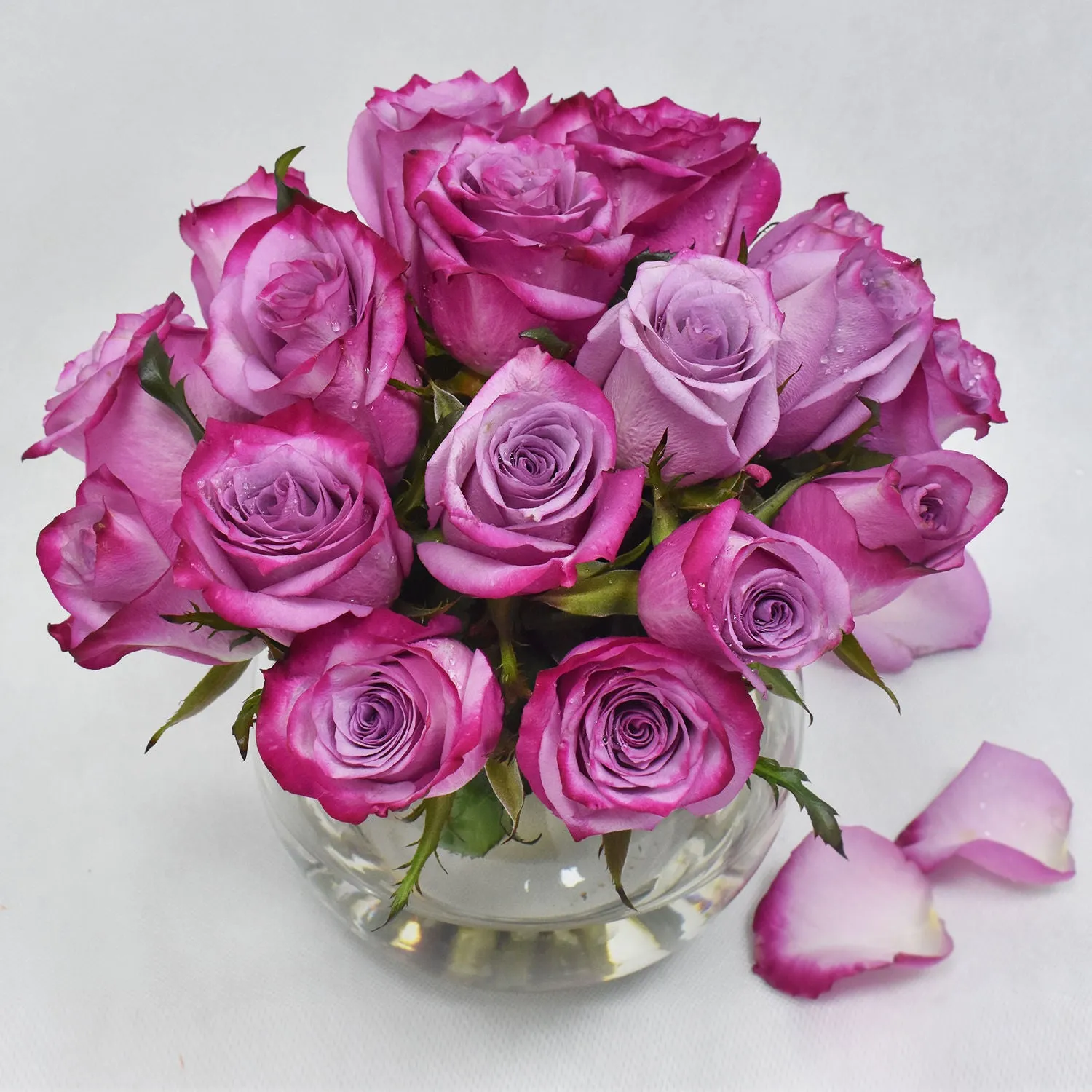 Elegant Arrangement of Purple Roses in a Glass Fish Bowl