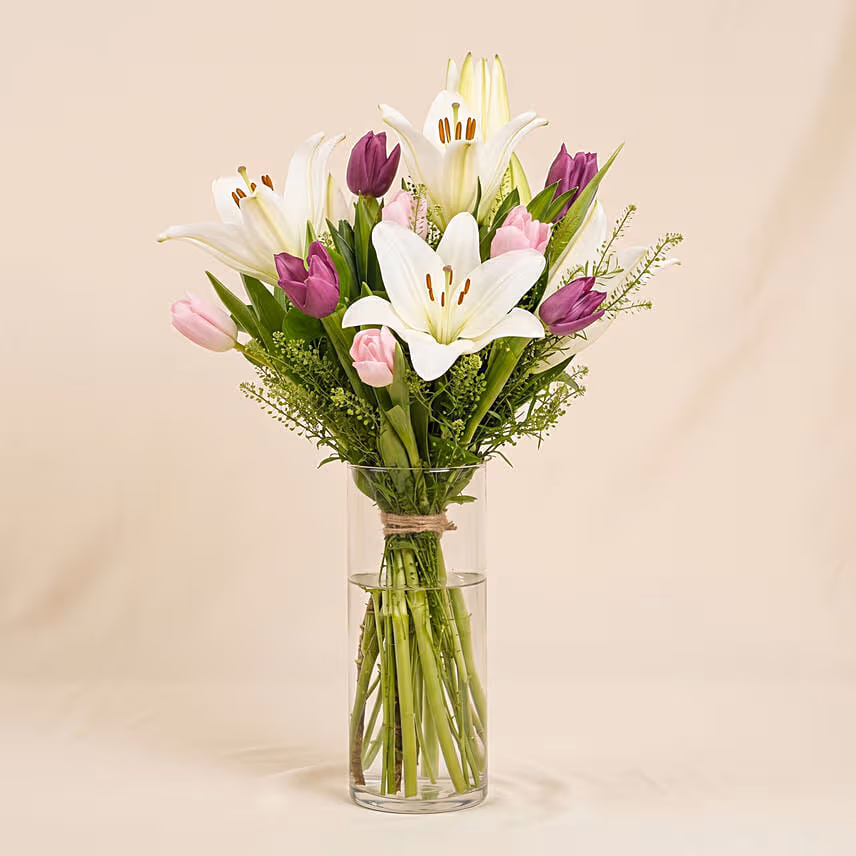 Medley Of Lilies And Tulips In Glass Vase