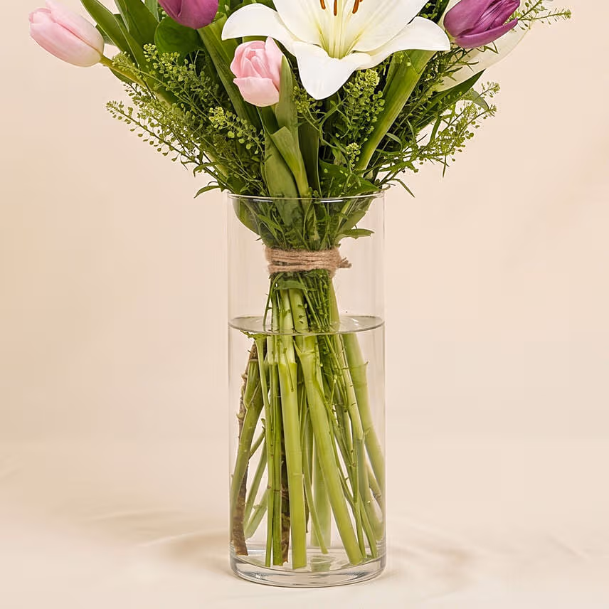 Medley Of Lilies And Tulips In Glass Vase